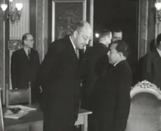 Dutch and Indonesian representatives meet in The Hague in December 1950, with a map locating New Guinea in the region.